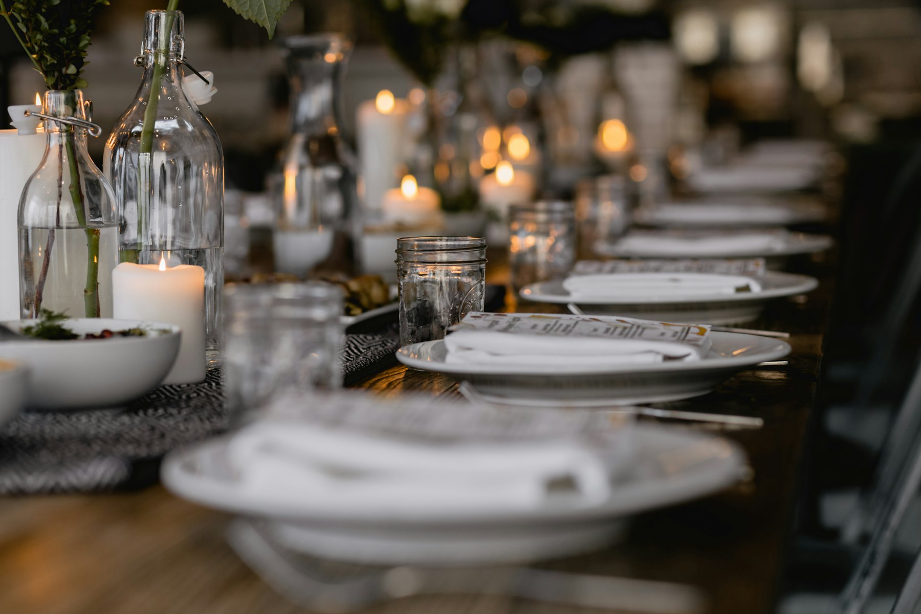 A long candlelit dining table laid for a private dinner