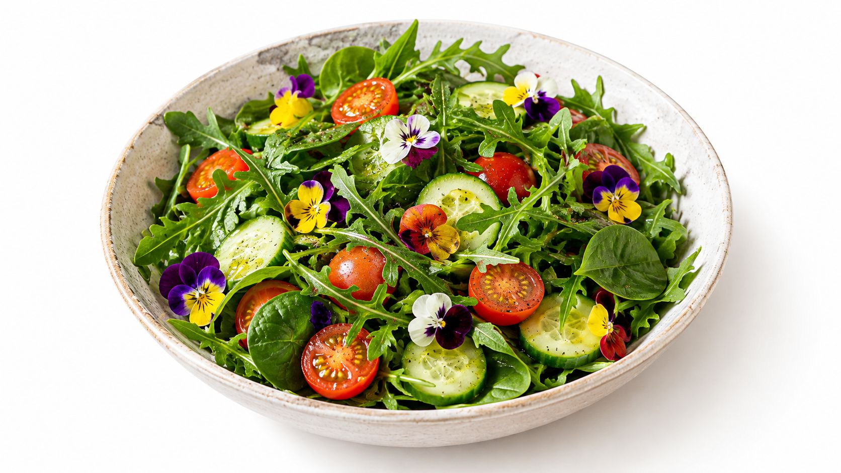 A fresh salad bowl filled with leafy greens, sliced cucumbers, cherry tomatoes, and vibrant edible pansy flowers.