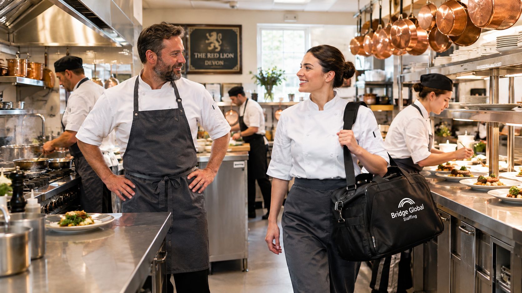 A professional chef team working in a busy commercial restaurant kitchen with stainless steel equipment.